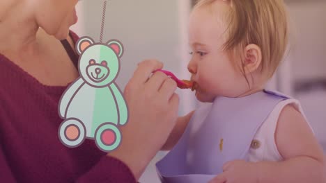 Animation-of-teddy-bear-icon-over-caucasian-mother-feeding-her-baby-with-spoon