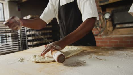 Animation-of-hands-of-diverse-female-and-male-bakers-rolling-sourdough-for-bread