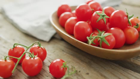 Video-of-fresh-cherry-tomatoes-in-bowl-over-wooden-background