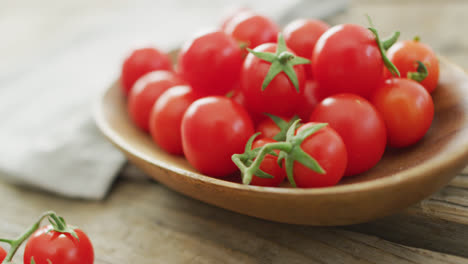 Video-of-fresh-cherry-tomatoes-in-bowl-over-wooden-background
