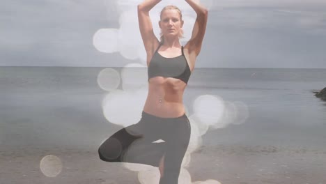 Animation-Von-Lichtflecken-über-Einer-Kaukasischen-Frau,-Die-Am-Strand-Yoga-Praktiziert