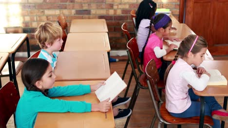 Cute-schoolchildren-reading-in-their-classroom