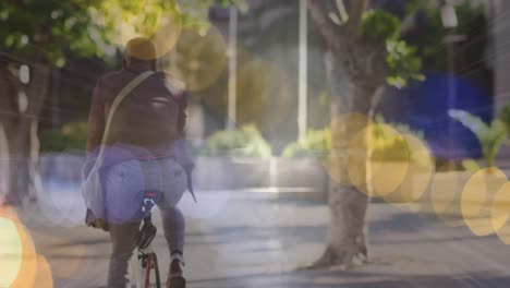 Animation-of-glowing-lights-over-african-american-businessman-cycling-in-city