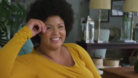 Video-Einer-Glücklichen-Afroamerikanerin-In-Übergröße,-Die-Auf-Dem-Sofa-Sitzt
