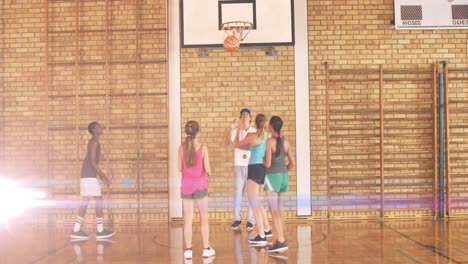 Animation-of-light-spots-over-diverse-schoolchildren-playing-basketball-at-gym