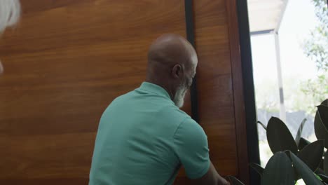 Glücklicher-älterer-Afroamerikanischer-Mann,-Der-Die-Tür-Im-Altersheim-öffnet