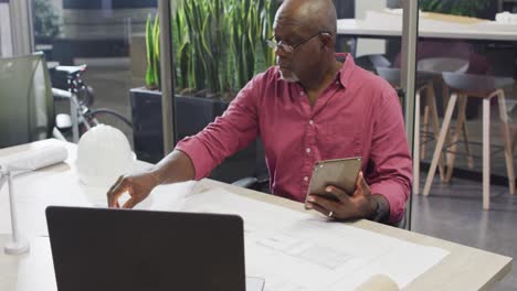 Video-of-focused-african-american-male-designer-working-with-tablet-on-project
