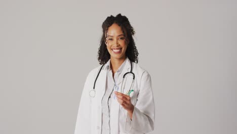 Video-of-smiling-biracial-female-doctor-holding-white-lung-cancer-ribbon