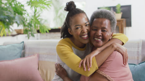 Portrait-of-african-american-mother-and-daughter-smiling-while-hugging-each-other-at-home