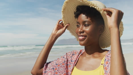 Porträt-Einer-Glücklichen-Afroamerikanischen-Frau-Mit-Hut-Am-Sonnigen-Strand