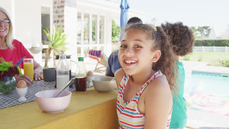 Video-of-biracial-girl-with-diverse-family-spending-time-together-and-having-dinner-outside