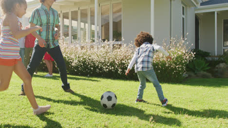 Video-Einer-Vielfältigen-Familie,-Die-Draußen-Ein-Fußballspiel-Spielt