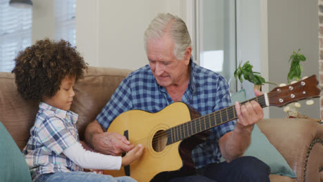 Video-Eines-Gemischtrassigen-Enkels-Und-Eines-Kaukasischen-Großvaters,-Die-Gemeinsam-Gitarre-Spielen