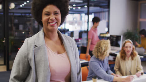 Portrait-of-happy-biracial-businesswoman-looking-at-camera-at-office