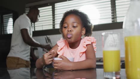 Video-of-african-american-father-and-daughter-preparing-breakfast