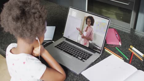 African-american-girl-using-laptop-for-video-call,-with-female-teacher-on-screen