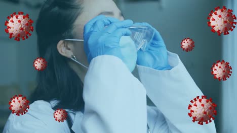 Animation-of-virus-cells-over-asian-female-doctor-with-face-mask