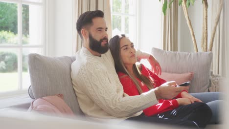 Video-Eines-Glücklichen-Kaukasischen-Paares,-Das-Auf-Dem-Sofa-Sitzt-Und-Fernsieht
