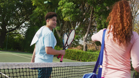 Video-Eines-Glücklichen-Gemischtrassigen-Paares,-Das-Auf-Dem-Platz-Tennis-Spielt