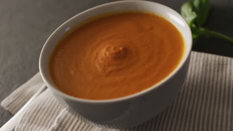 Video-of-cream-tomato-soup-in-bowl-on-grey-table