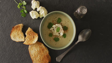 Video-of-cauliflower-soup-and-ingredients-lying-on-grey-surface