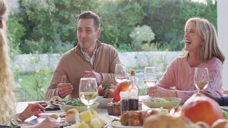 Video-of-happy-caucasian-father-telling-story-at-outdoor-family-dinner-table