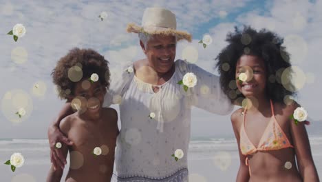 Animation-of-spots-and-flowers-over-happy-african-american-grandmother-and-grandchildren-on-beach