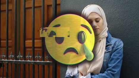Animation-Von-Emojis,-Die-über-Eine-Muslimische-Frau-Weinen,-Die-Ihr-Smartphone-Benutzt