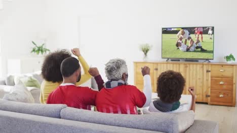 Video-of-african-american-family-sitting-on-the-couch-and-watching-football-match