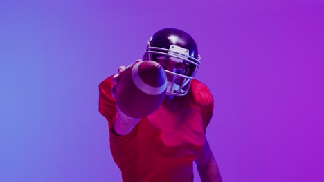 Video-of-caucasian-american-football-player-in-helmet-with-ball-over-neon-purple-background