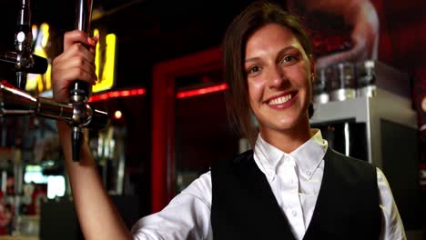 Smiling-barkeeper-holding-beer-pump