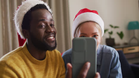Feliz-Grupo-De-Amigos-Diversos-Usando-Un-Teléfono-Inteligente-Para-Videollamadas-En-La-Fiesta-De-Navidad