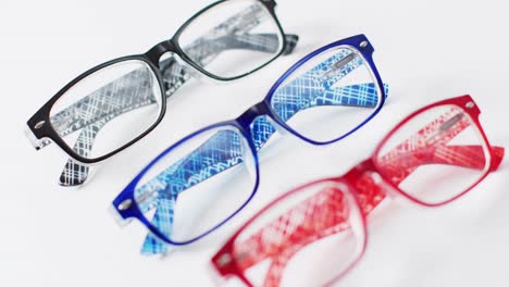 Video-of-three-coloured-pairs-of-glasses-on-white-background-with-rack-focus