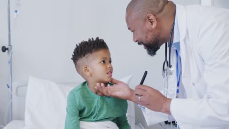 Médico-Varón-Afroamericano-Examinando-A-Un-Paciente-Infantil-En-El-Hospital