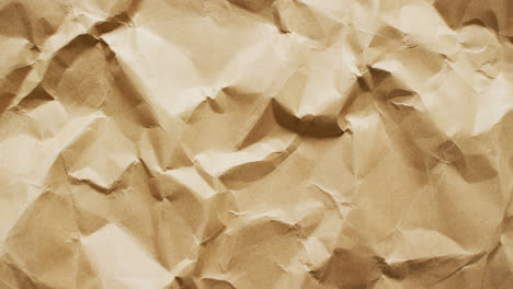 Video-of-close-up-of-crumpled-brown-paper-texture-background