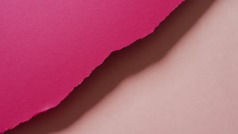 Video-of-close-up-of-torn-pieces-of-dark-and-light-pink-paper-background