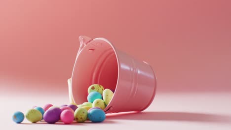 Bucket-with-colorful-easter-eggs-on-pink-background-with-copy-space
