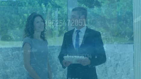 Animation-of-changing-numbers-over-caucasian-male-real-estate-agent-showing-a-house-to-a-woman