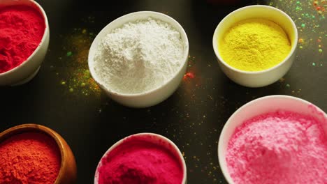 Video-of-multi-coloured-powder-in-bowls-with-copy-space-on-black-background