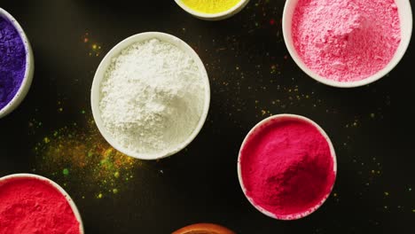 Video-of-multi-coloured-powder-in-bowls-with-copy-space-on-black-background