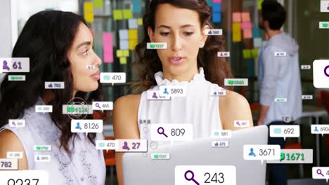 Animation-of-changing-numbers-with-notification-icons-over-diverse-women-discussing-ideas-on-laptop