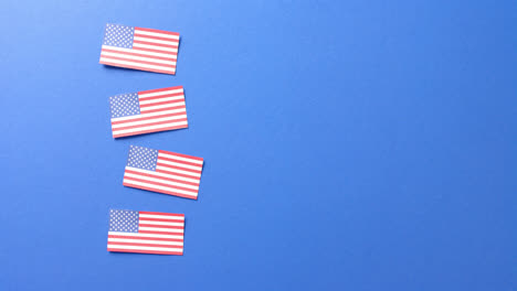 Four-national-flags-of-usa-lying-on-blue-background-with-copy-space