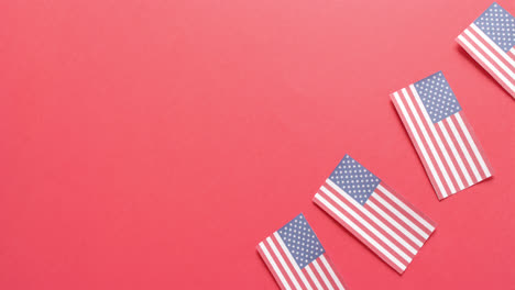Four-national-flags-of-usa-lying-on-red-background-with-copy-space
