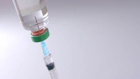 Close-up-of-insulin-vial-and-syringe-on-grey-background-with-copy-space,-slow-motion