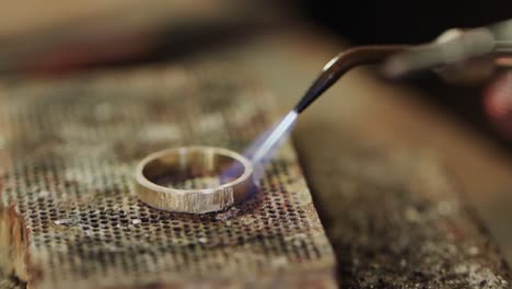 Close-up-of-shaping-ring-with-blowtorch-in-workshop-in-slow-motion