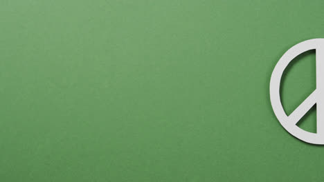 Nahaufnahme-Eines-Weißen-Friedenszeichens-Und-Kopierraum-Auf-Grünem-Hintergrund