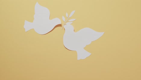 Nahaufnahme-Von-Weißen-Tauben-Mit-Blatt-Und-Kopierraum-Auf-Gelbem-Hintergrund