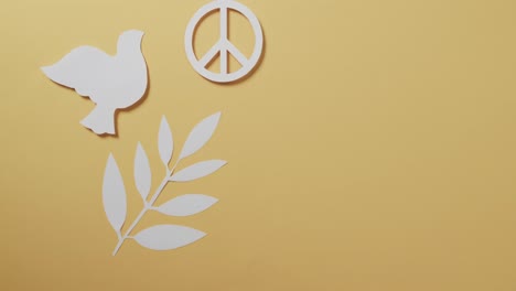 Nahaufnahme-Einer-Weißen-Taube-Mit-Friedenszeichen-Und-Blatt-Und-Kopierraum-Auf-Gelbem-Hintergrund