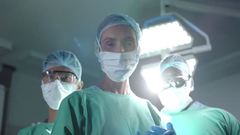 Portrait-of-serious-diverse-surgeons-with-face-masks-in-operating-room-in-slow-motion