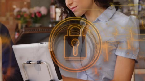 Animation-of-security-padlock-and-light-trails-over-biracial-woman-using-digital-tablet-at-a-bar